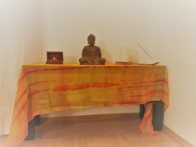 Kleiner Altar mit Kerze, Rauchwerk und Buddha